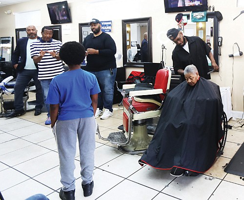 Henrico County Supervisor Tyrone Nelson speaks at Unlimited Barber Shop in Richmond about registering and voting for the Democratic presidential ticket of Harris and Walz.
Listening are Delegate Michael J. Jones, left, and state Sen. Lamont Bagby, who also shared their views during the Virginia Democrats’ “Barbershop Talk Tour.” Afterward, 10-year-old Nii-Armah Ayree boldly asked the first question about Vice President Kamala Harris’ plans if elected president.