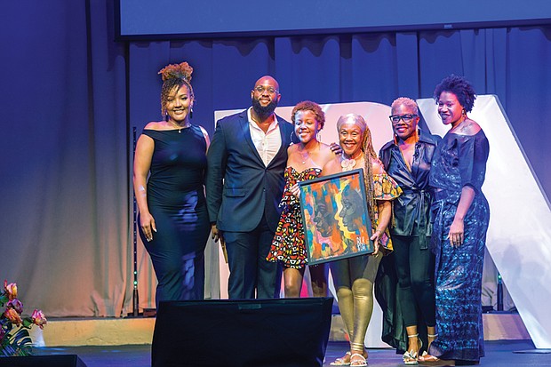 Elegba Folklore Society founder Janine Bell along with daughtes Imani Bell and grand- daughter Yaa-Nailah Bell-Barber accept the Cultural Preservation Award at the inaugural BLK RVA Community Awards this past Friday night at The Hippodrome Theater. Also pictured, Anissa Turner Randolph, chair of the BLK RVA Advisory Board, Greg Gallop, philanthropic associate of The Community Foundation and show host Clovia Lawrence.