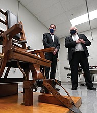 Former Virginia Gov. Ralph Northam, left, looks over the electric chair in the death chamber at Greensville Correctional Center with Operations Director George Hinkle, center, and Warden Larry Edmonds, right, prior to signing a bill on March 24, 2021, abolishing the death penalty in the state.