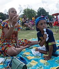 Soliel Lindsey and her 5-year-old son, Samaad Lindsey-Jones, enjoy ice cream at Abner Clay Park in Jackson Ward during the 33rd Down Home Family Reunion on Aug. 17.