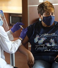 A COVID-19 vaccine is administered to a resident of Highland Park Senior Apartments in 2021.