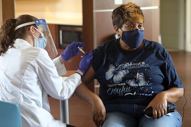 A COVID-19 vaccine is administered to a resident of Highland Park Senior Apartments in 2021.