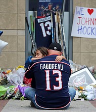 Shiloh Rivera, facing, mourns with Hylas Stemen of Columbus, at the makeshift memorial set up by fans for Blue Jackets hockey player Johnny Gaudreau in Columbus, Ohio, Friday, Aug. 30.
Mandatory Credit:	Joe Maiorana/AP via CNN Newsource