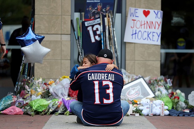 Shiloh Rivera, facing, mourns with Hylas Stemen of Columbus, at the makeshift memorial set up by fans for Blue Jackets hockey player Johnny Gaudreau in Columbus, Ohio, Friday, Aug. 30.
Mandatory Credit:	Joe Maiorana/AP via CNN Newsource