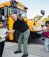 Students at Cardinal Elementary School are greeted by Assistant Principal Baylan Smith. The South Side school reopened this week after damage from a lightning strike on Aug. 26.
