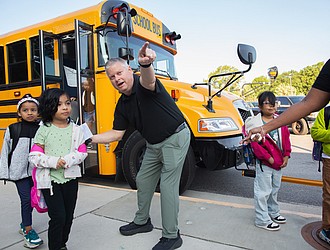 Students at Cardinal Elementary School are greeted by Assistant Principal Baylan Smith. The South Side school reopened this week after damage from a lightning strike on Aug. 26.