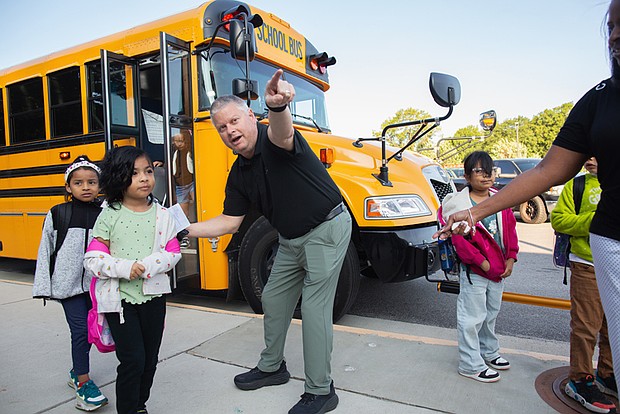Students at Cardinal Elementary School are greeted by Assistant Principal Baylan Smith. The South Side school reopened this week after damage from a lightning strike on Aug. 26.
