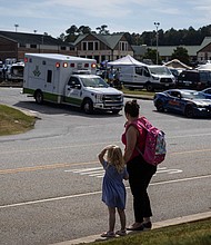 A young girl and her mother watch as law enforcement and first responders surround Apalachee High School in Winder, Georgia.
Mandatory Credit:	Christian Monterrosa/AFP/Getty Images via CNN Newsource