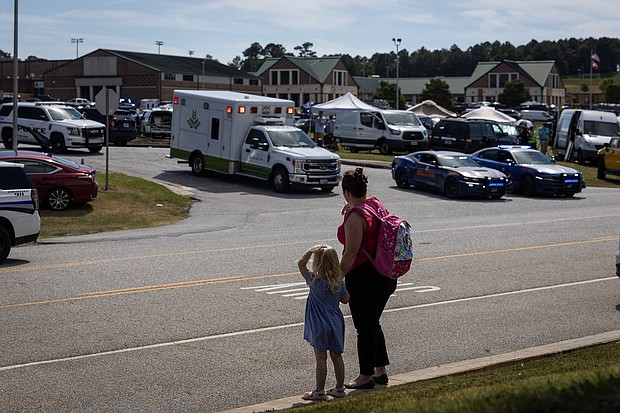 A young girl and her mother watch as law enforcement and first responders surround Apalachee High School in Winder, Georgia.
Mandatory Credit:	Christian Monterrosa/AFP/Getty Images via CNN Newsource