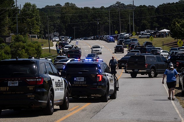 Authorities found documents that they believe reference past school shootings in the home of the 14-year-old accused of shooting at Apalachee High School, and law enforcement are pictured after the shooting in Winder, Georgia, on September 4.
Mandatory Credit:	Christian Monterrosa/AFP/Getty Images via CNN Newsource