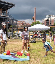 Vi’sjay Murphy, 3 , plays cornhole under the watchful eye of Mattia Pekanyande, Nala Jones, Miles Pekanyande and Zuri Arnold during the James River EcoFest Sept. 7 at the James A. Buzzard River Education Center.