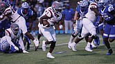 Virginia Union running back Jada Byers pushes through Hampton’s defense during a hard-fought game, where he rushed for 105 yards and two touchdowns.