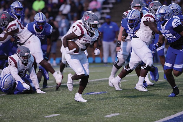 Virginia Union running back Jada Byers pushes through Hampton’s defense during a hard-fought game, where he rushed for 105 yards and two touchdowns.