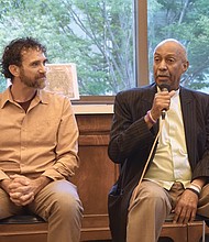 Director of The Humanization Project and former prisoner Taj Mahon-Haft looks on as Pastor Rodney Hunter speaks during a panel discussion as part of the opening of the “Virginia Needs a Second Chance” exhibition at the Richmond Public Library last Friday evening.