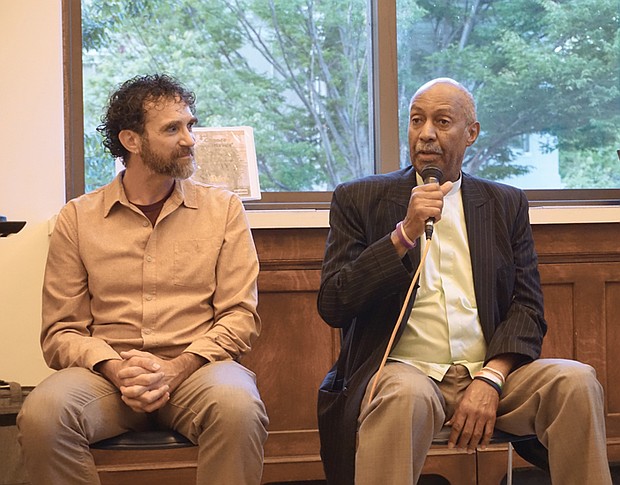 Director of The Humanization Project and former prisoner Taj Mahon-Haft looks on as Pastor Rodney Hunter speaks during a panel discussion as part of the opening of the “Virginia Needs a Second Chance” exhibition at the Richmond Public Library last Friday evening.