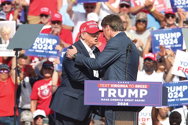 Former President Donald Trump shakes hands with Virginia Gov. Glenn Youngkin at a rally in Chesapeake, June 28, 2024.