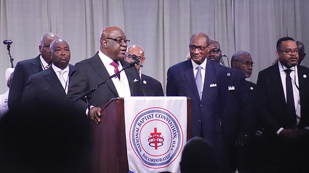 The Rev. Boise Kimber, at podium, president-elect of NBCUSA, addresses the close of the National Baptist Convention, USA annual meeting Sept. 5 at the Baltimore Convention Center in Baltimore. The Rev. Jerry Young, center right, outgoing NBCUSA president, listens to Kimber.