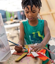Joseph decorates a mask he made during ART 180’s Block Party on May 3.