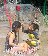 Milan Rock, 2, plays with Isabella Licona, 6, at Dunncroft/Castle Point Park Spray Park in Henrico County on July 5.
