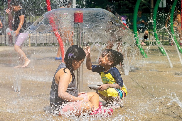 Milan Rock, 2, plays with Isabella Licona, 6, at Dunncroft/Castle Point Park Spray Park in Henrico County on July 5.