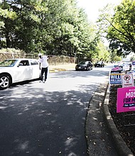 Early voters arrive at the Richmond Office of Elections on West Laburnum Avenue on Sept. 20 as a
poll worker provides assistance.