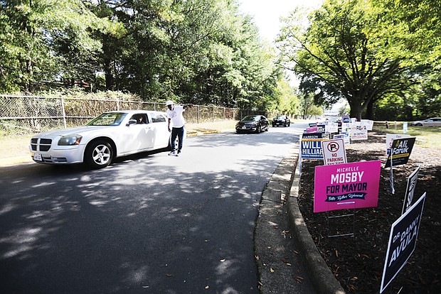 Early voters arrive at the Richmond Office of Elections on West Laburnum Avenue on Sept. 20 as a
poll worker provides assistance.