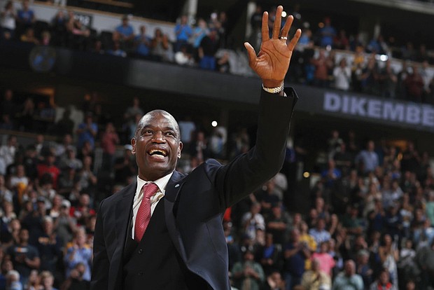 Retired Denver Nuggets center Dikembe Mutombo waves to the crowd as his jersey number is retired by the team during halftime of the Nuggets’ basketball game against the Portland Trail Blazers on Oct. 29, 2016, in Denver.