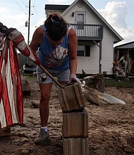 Roxanne Brooks mounts an American flag to a stack of cinderblocks outside her friend's destroyed mobile home (R) in the aftermath of Hurricane Helene flooding on October 6 in Swannanoa, North Carolina.
Mandatory Credit:	Mario Tama/Getty Images via CNN Newsource