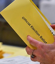 In this November 2023 photo, a woman takes a mail-in ballot from an envelope at a polling station in Pennsylvania.
Mandatory Credit:	Aimee Dilger/SOPA Images/Getty Images via CNN Newsource