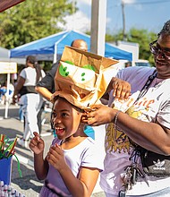 Jamaya Mills helps her daughter Amari-Elle Mills, 7, try on her handmade hat at the Science Museum booth Oct. 5 at the 2nd Street Festival.