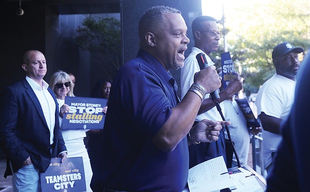 Brian Peyton, center, president of Teamsters 322, addresses a crowd from the back steps of Richmond City Hall on
Tuesday, Oct. 8. Speaking on behalf of City of Richmond city workers, Peyton criticized Mayor Levar M. Stoney’s administration for not taking labor negotiations seriously.