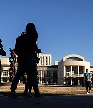 Silhouettes of students in front of the M.D Anderson Library in late afternoon light. January 25, 2024.