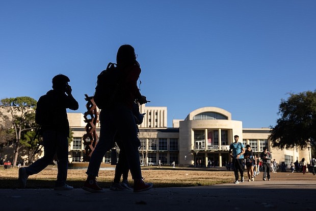 Silhouettes of students in front of the M.D Anderson Library in late afternoon light. January 25, 2024.