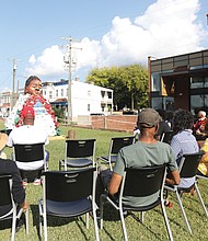 Community members gather around “Umama, and so she sows,” a community monument created by ART 180. The sculpture, honoring Black women’s contributions, was unveiled at its temporary location between Ebenezer Baptist Church and the Black History Museum in Jackson Ward. Led by artists Natassja Swift and Xolani Sivunda, the project involved local youths and symbolizes cultural connectivity and healing.