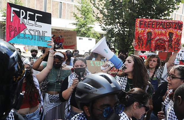 Sereen Haddad, a junior at Virginia Commonwealth University with bullhorn, leads a student-organized walkout on Monday, Oct. 7. The demonstration, marking one year since the start of the Israel-Hamas conflict, saw about 100 participants march from the Monroe Park Campus to the Virginia General Assembly Building on East Broad Street.