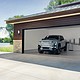 2025 GMC Sierra EV Denali in Thunderstorm Gray charging with GM Energy products inside a garage.