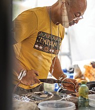 Manuel Corona Sr., owner of Khepra Jewelers crafts a new piece at his booth at the Richmond Folk Festival.