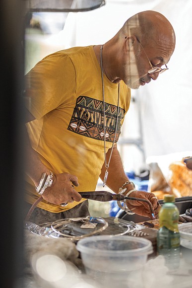 Manuel Corona Sr., owner of Khepra Jewelers crafts a new piece at his booth at the Richmond Folk Festival.