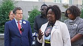 Caroline Ouko, mother of Irvo Otieno, speaks as attorney Mark Krudys and others look on Monday during a press conference calling for a U.S. Department of Justice investigation into Otieno’s death outside the U.S. District Courthouse at 701 E. Broad St.