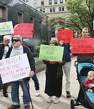 Tenants and allies facing issues with their landlords listen Tuesday to speakers during a Virginia Organizing press conference outside Richmond City Hall.