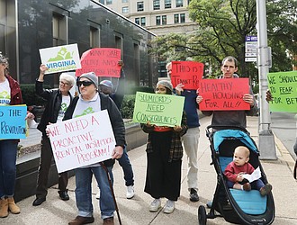 Tenants and allies facing issues with their landlords listen Tuesday to speakers during a Virginia Organizing press conference outside Richmond City Hall.