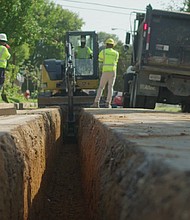 Construction workers dig up legacy gas lines to replace them with more durable materials.