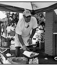 Richard Walker cooks at a fish fry in Gilpin Court in Richmond. He was using the event to help former convicts with prior felony convictions restore their voting rights.
