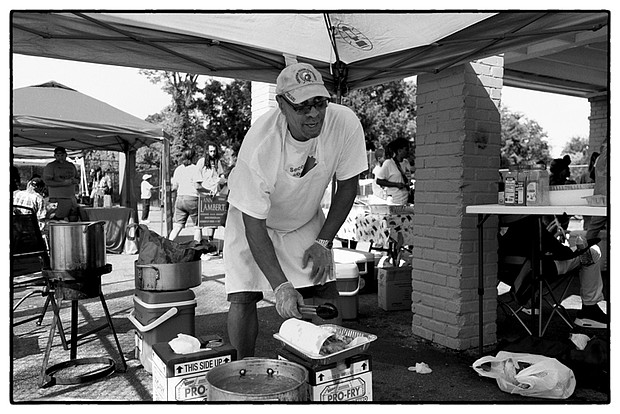 Richard Walker cooks at a fish fry in Gilpin Court in Richmond. He was using the event to help former convicts with prior felony convictions restore their voting rights.