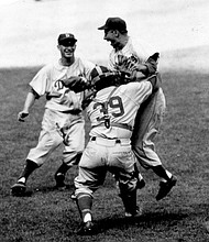 Brooklyn Dodgers pitcher Johnny Podres is lifted by catcher Roy Campanella (39) after the final out of the seventh and deciding game of the World Series at Yankee Stadium, Oct. 4, 1955, in New York.