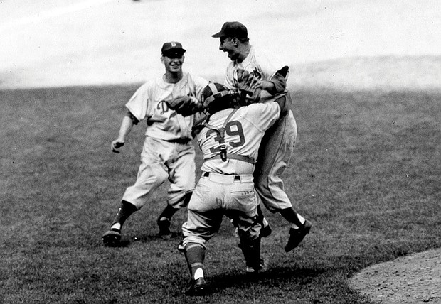Brooklyn Dodgers pitcher Johnny Podres is lifted by catcher Roy Campanella (39) after the final out of the seventh and deciding game of the World Series at Yankee Stadium, Oct. 4, 1955, in New York.