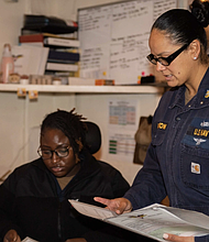 Senior Chief Yeoman Amberina Panton, a native of Corpus Christi, Texas, right, reviews administrative paperwork with Yeoman 1st Class Aderonk Oki, a native of Houston, Texas. (U.S. Navy photo by Mass Communication Specialist Seaman Amber Rivette)