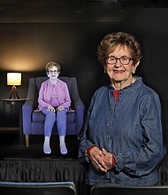 Holocaust survivor Halina Zimm stands next to her interactive image in the Alan and Halina Zimm Theater of Remembrance at the Virginia Holocaust Museum where visitors can engage with her powerful story.