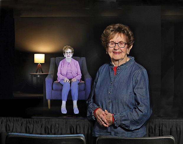 Holocaust survivor Halina Zimm stands next to her interactive image in the Alan and Halina Zimm Theater of Remembrance at the Virginia Holocaust Museum where visitors can engage with her powerful story.