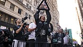 New York Liberty guard Sabrina Ionescu holds up the WNBA basketball championship trophy while riding down Broadway during a parade celebrating the team’s season championship, Thursday, Oct. 24, in New York.